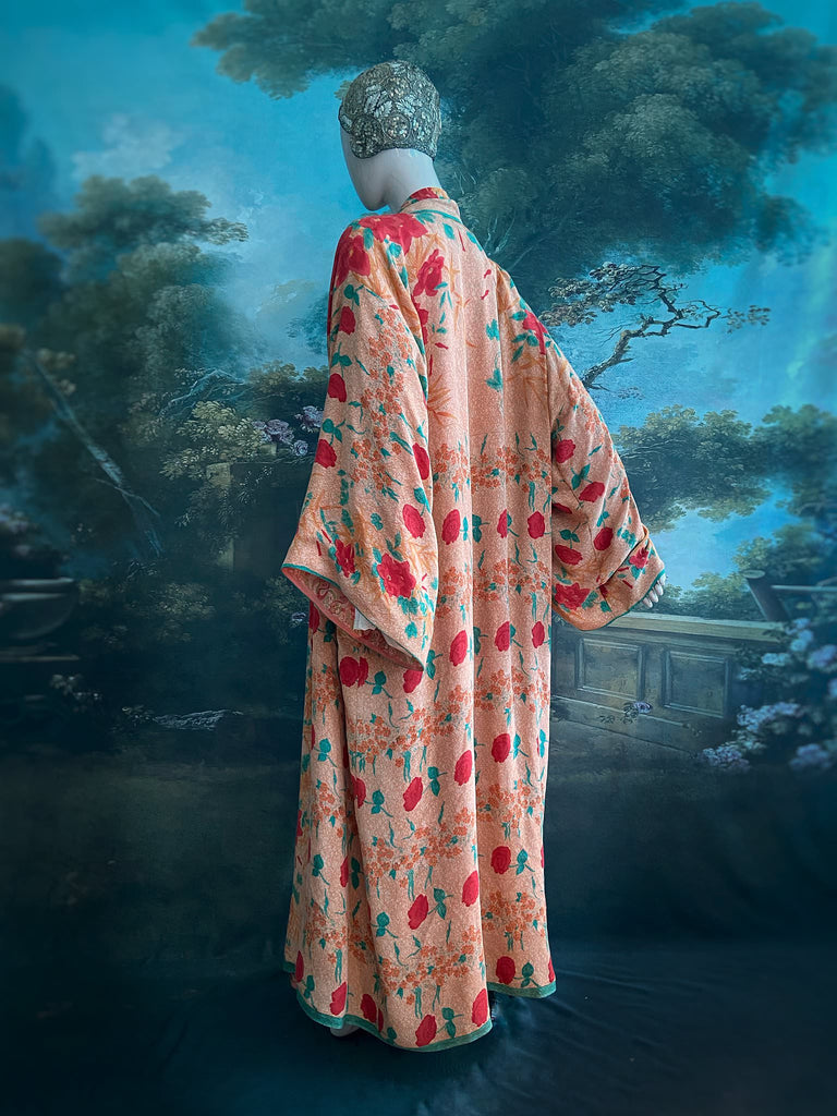 Full length 1920s 1930s Deco inspired kimono robe with large patch pockets. Newly created from a peach and mint green block print rose vintage silk crepe. Kimono collar and wide sleeves. Fully lined in silk with French seams throughout. Bohemian styles sustainably created from antique and vintage textiles by the Pavilion Parade studio.