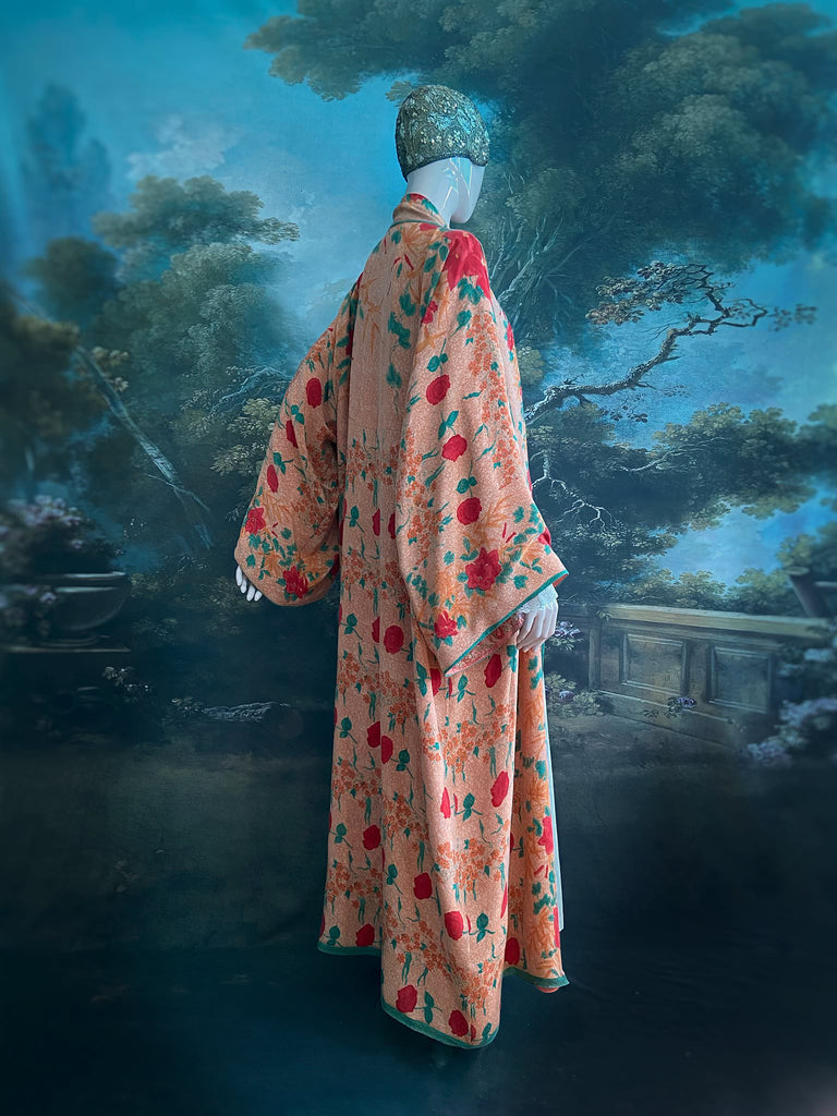 Full length 1920s 1930s Deco inspired kimono robe with large patch pockets. Newly created from a peach and mint green block print rose vintage silk crepe. Kimono collar and wide sleeves. Fully lined in silk with French seams throughout. Bohemian styles sustainably created from antique and vintage textiles by the Pavilion Parade studio.