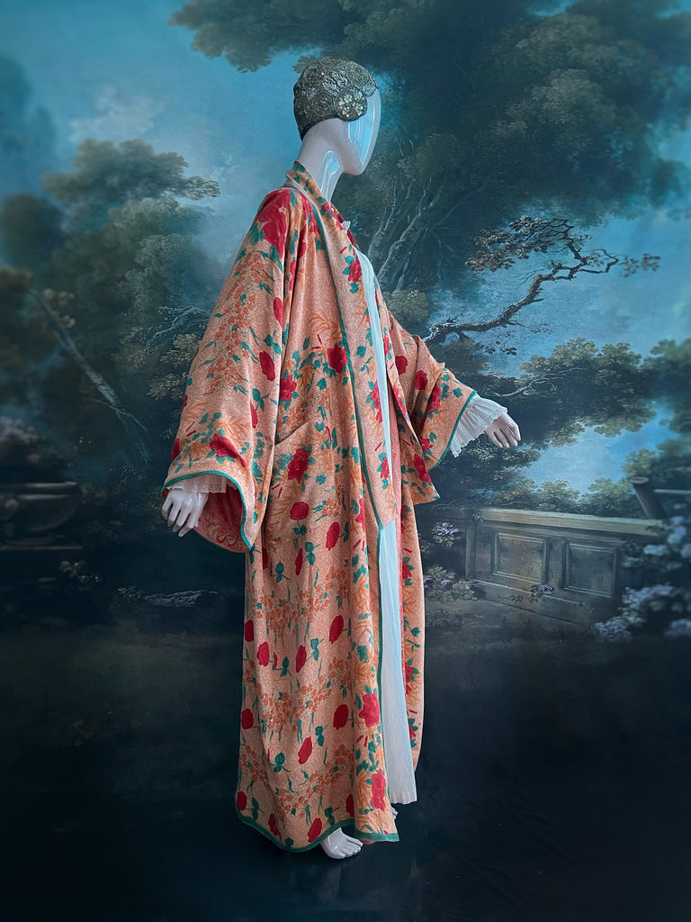 Full length 1920s 1930s Deco inspired kimono robe with large patch pockets. Newly created from a peach and mint green block print rose vintage silk crepe. Kimono collar and wide sleeves. Fully lined in silk with French seams throughout. Bohemian styles sustainably created from antique and vintage textiles by the Pavilion Parade studio.