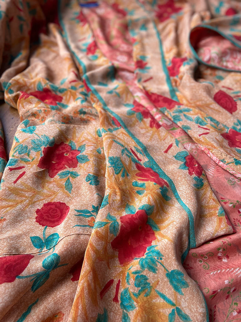 Full length 1920s 1930s Deco inspired kimono robe with large patch pockets. Newly created from a peach and mint green block print rose vintage silk crepe. Kimono collar and wide sleeves. Fully lined in silk with French seams throughout. Bohemian styles sustainably created from antique and vintage textiles by the Pavilion Parade studio.
