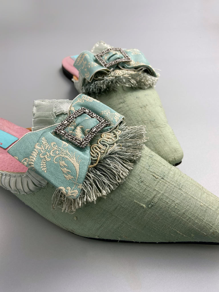 Eau de Nil silk pointed toe shoes in the  Georgian style. Embellished with silk ribbon bows and cut steel antique buckles. Bohemian styles sustainably created from antique textiles by Pavilion Parade.