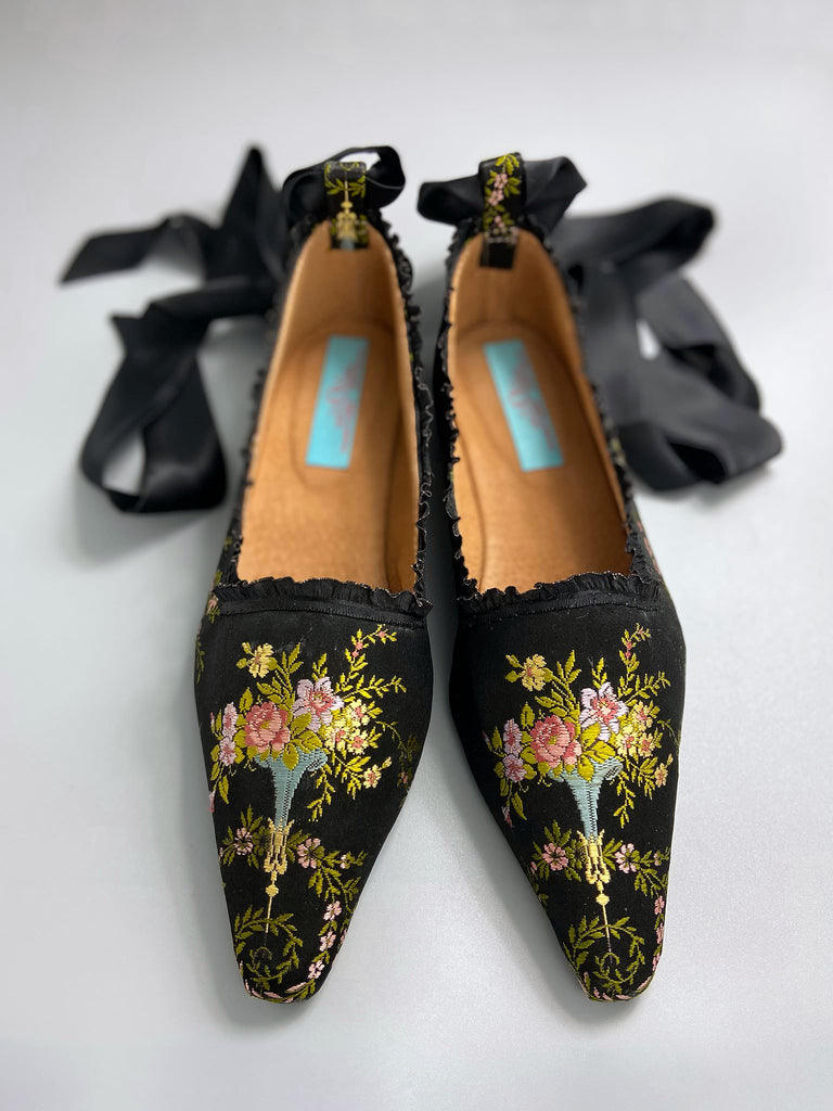 Black silk regency slipper shoes with floral embroidered posy motif.  Pointed toes and black silk satin ankle ribbons. Bohemian style created from antique textiles by the Pavilion Parade studio.