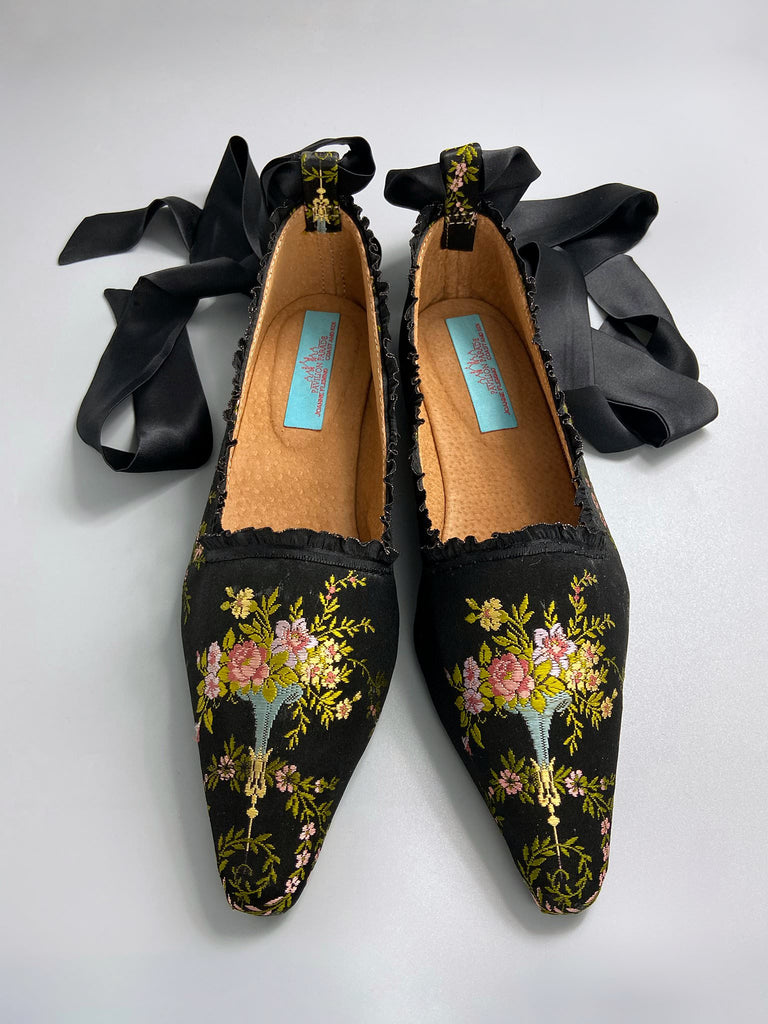 Black silk regency slipper shoes with floral embroidered posy motif.  Pointed toes and black silk satin ankle ribbons. Bohemian style created from antique textiles by the Pavilion Parade studio.