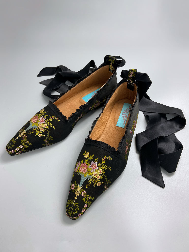 Black silk regency slipper shoes with floral embroidered posy motif.  Pointed toes and black silk satin ankle ribbons. Bohemian style created from antique textiles by the Pavilion Parade studio.
