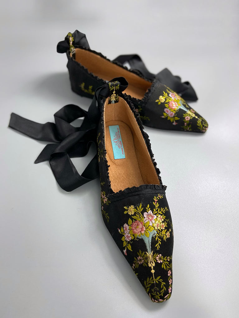 Black silk regency slipper shoes with floral embroidered posy motif.  Pointed toes and black silk satin ankle ribbons. Bohemian style created from antique textiles by the Pavilion Parade studio.