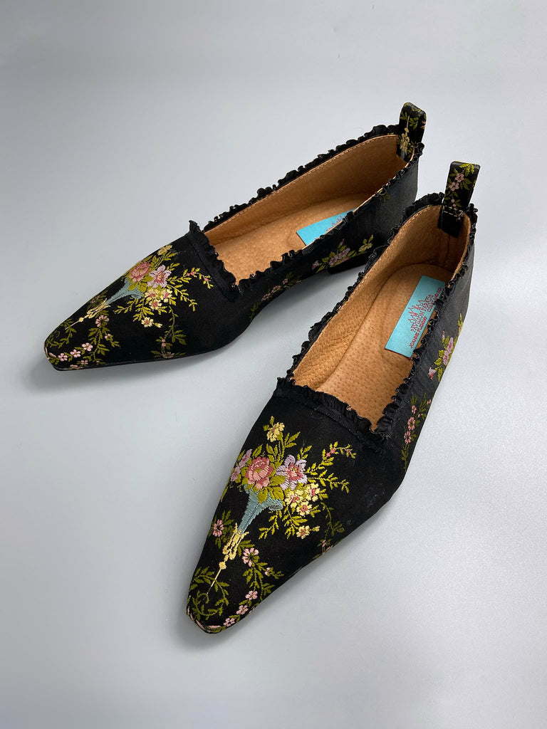 Black silk regency slipper shoes with floral embroidered posy motif.  Pointed toes and black silk satin ankle ribbons. Bohemian style created from antique textiles by the Pavilion Parade studio.