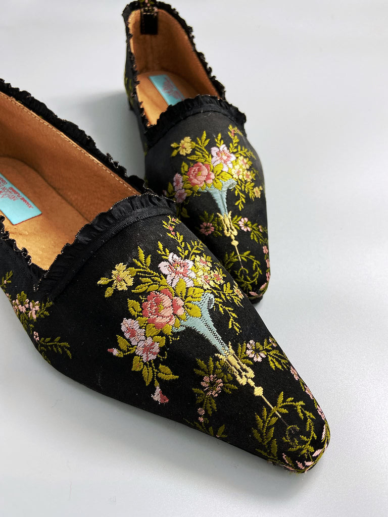 Black silk regency slipper shoes with floral embroidered posy motif.  Pointed toes and black silk satin ankle ribbons. Bohemian style created from antique textiles by the Pavilion Parade studio.
