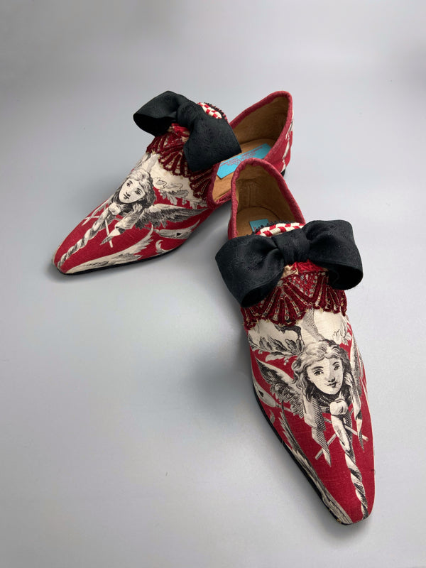 Red, black and white pointed toe bohemian shoes or slippers with a neo-classical winged god motif. Large black silk ribbon bows. Created from antique textiles by Pavilion Parade