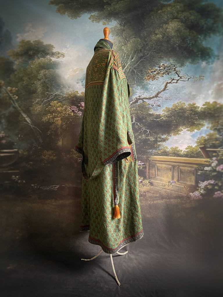 Forest green, conker brown and saffron yellow floral fine wool robe with silk lining. Wide sleeves, deep pockets and tassel sash. Unique bohemian style created from vintage and antique textiles by the Pavilion Parade studio.
