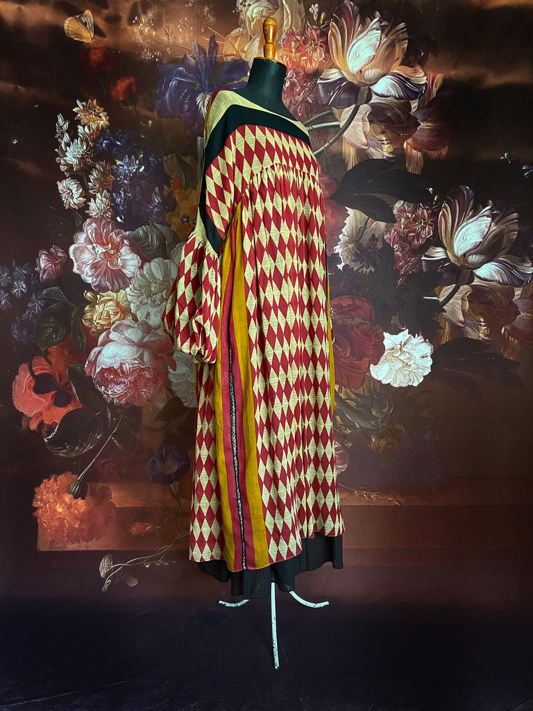 Harlequin red, yellow and black volume dress with long full sleeves and pockets. Bohemian style sustainably created from antique and vintage textiles by the Pavilion Parade studio