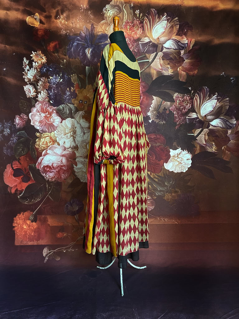 Harlequin red, yellow and black volume dress with long full sleeves and pockets. Bohemian style sustainably created from antique and vintage textiles by the Pavilion Parade studio