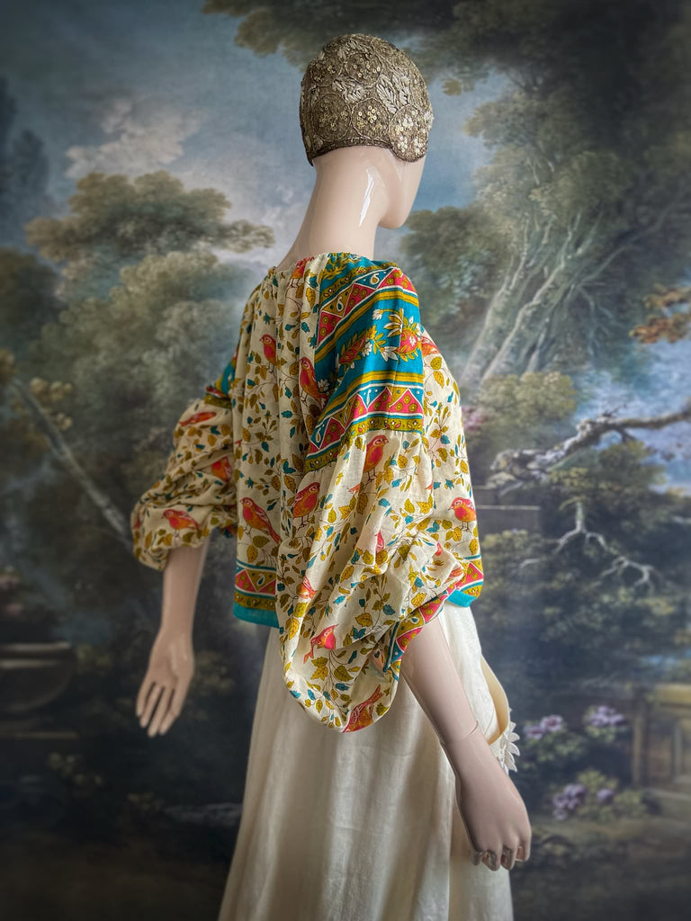 Coral, blue and ivory cotton muslin bird printed blouse with long full sleeves and adjustable drawstring neckline. Bohemian styles sustainably created from antique and vintage textiles by the Pavilion Parade studio. 