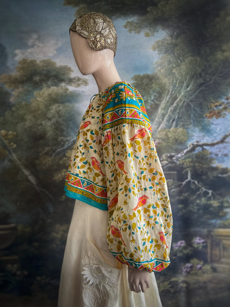 Coral, blue and ivory cotton muslin bird printed blouse with long full sleeves and adjustable drawstring neckline. Bohemian styles sustainably created from antique and vintage textiles by the Pavilion Parade studio. 