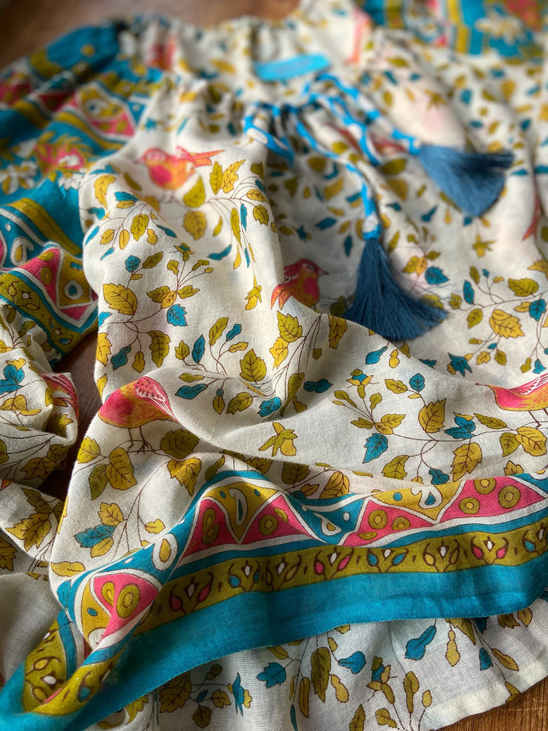 Coral, blue and ivory cotton muslin bird printed blouse with long full sleeves and adjustable drawstring neckline. Bohemian styles sustainably created from antique and vintage textiles by the Pavilion Parade studio. 