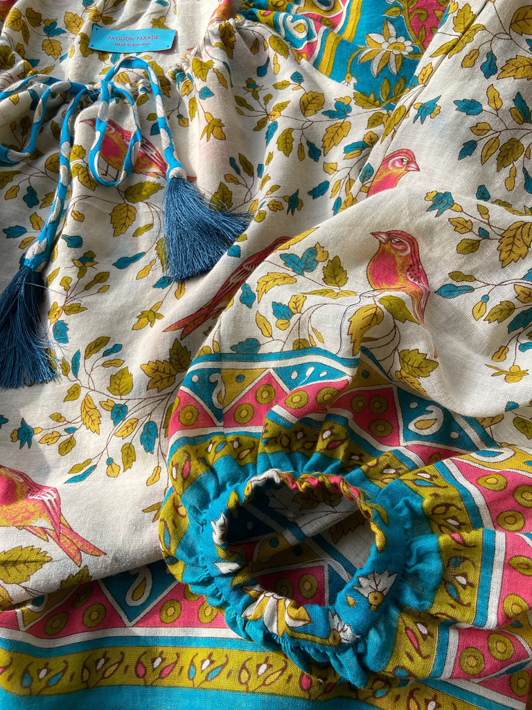 Coral, blue and ivory cotton muslin bird printed blouse with long full sleeves and adjustable drawstring neckline. Bohemian styles sustainably created from antique and vintage textiles by the Pavilion Parade studio. 
