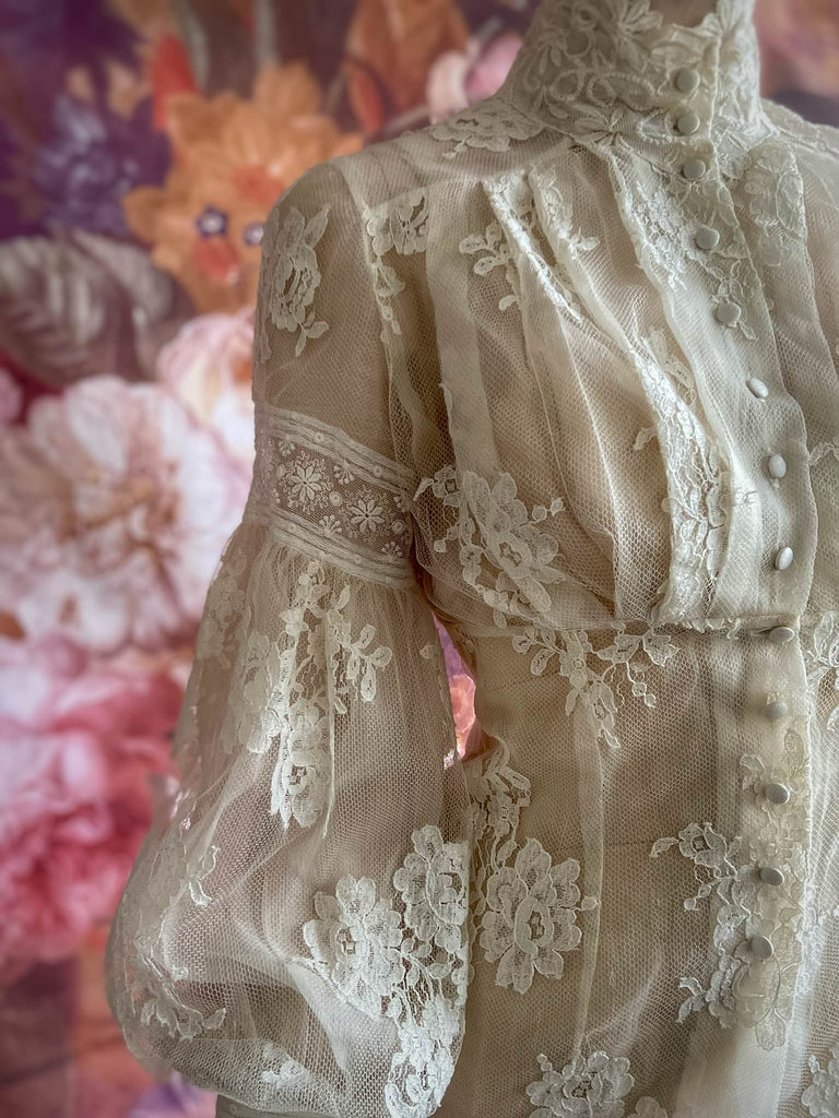 Ivory French lace and silk organza fitted romantic blouse. Antique lace elements at high fitted collar and cuffs. Full bishop sleeves and pleated bodice front. A flight of fancy from the Pavilion Parade studio. 