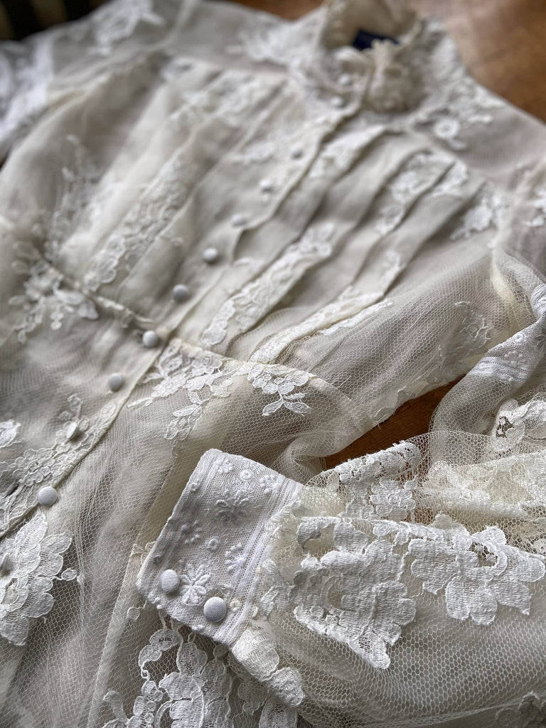 Ivory French lace and silk organza fitted romantic blouse. Antique lace elements at high fitted collar and cuffs. Full bishop sleeves and pleated bodice front. A flight of fancy from the Pavilion Parade studio. 