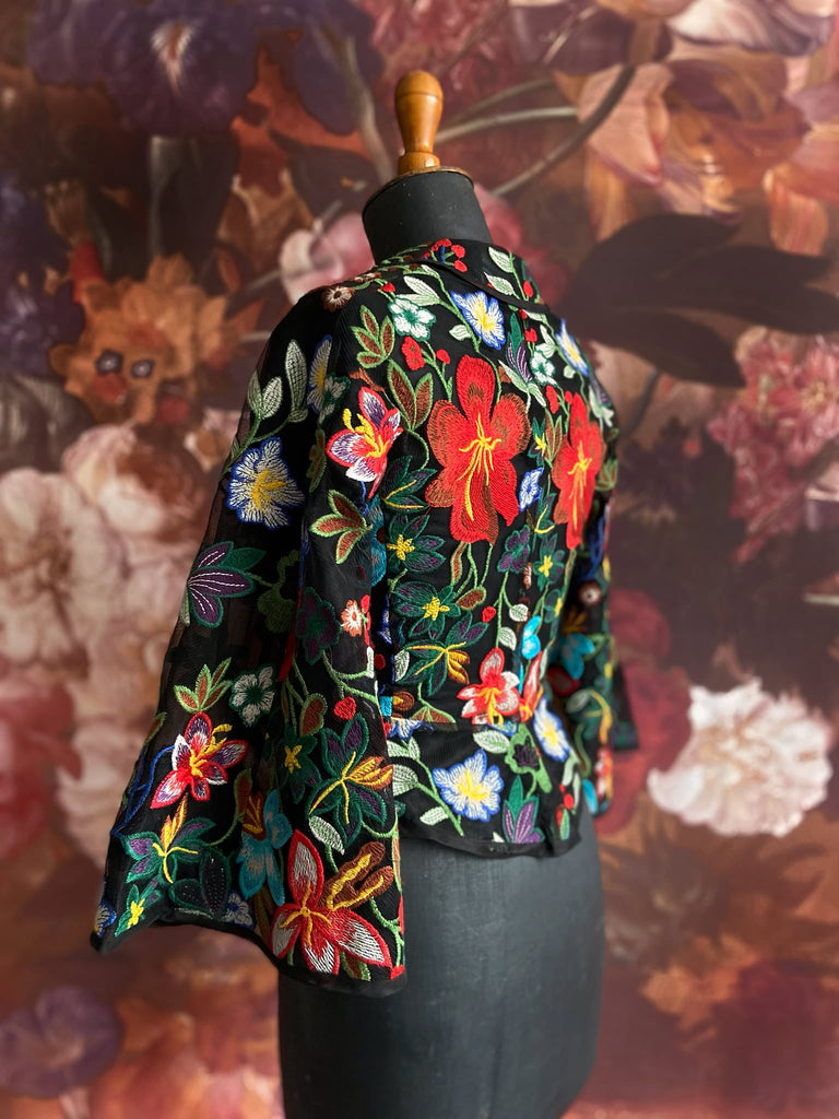 Frida Kahlo inspired embroidered silk and tulle bodice jacket with picture neckline and pagoda sleeves. Vivid black, red, green and blue floral. Flight of fancy from the Pavilion Parade studio. 