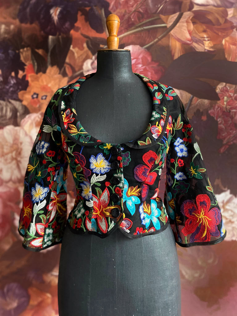 Frida Kahlo inspired embroidered silk and tulle bodice jacket with picture neckline and pagoda sleeves. Vivid black, red, green and blue floral. Flight of fancy from the Pavilion Parade studio. 