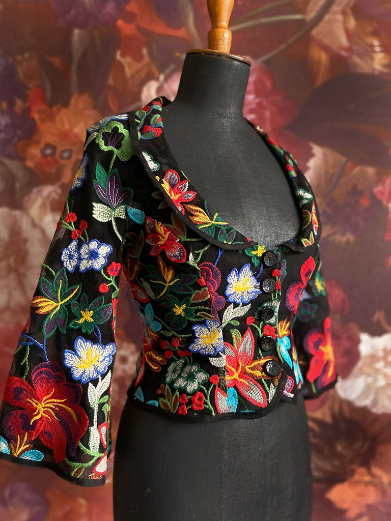 Frida Kahlo inspired embroidered silk and tulle bodice jacket with picture neckline and pagoda sleeves. Vivid black, red, green and blue floral. Flight of fancy from the Pavilion Parade studio. 
