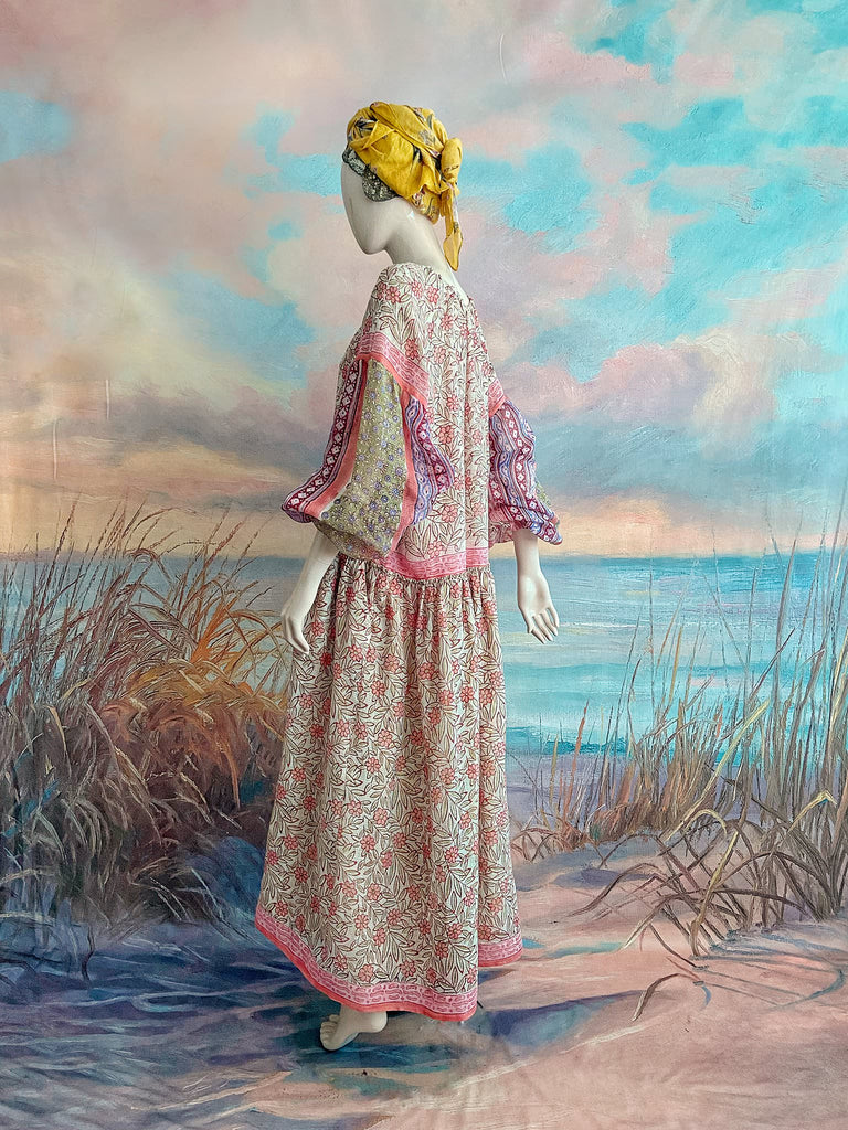 Summer floral apricot and lavender fine handwoven cotton block printed dress with long full sleeves and adjustable drawstring neckline. Bohemian styles sustainably created from antique and vintage textiles by the Pavilion Parade studio. 