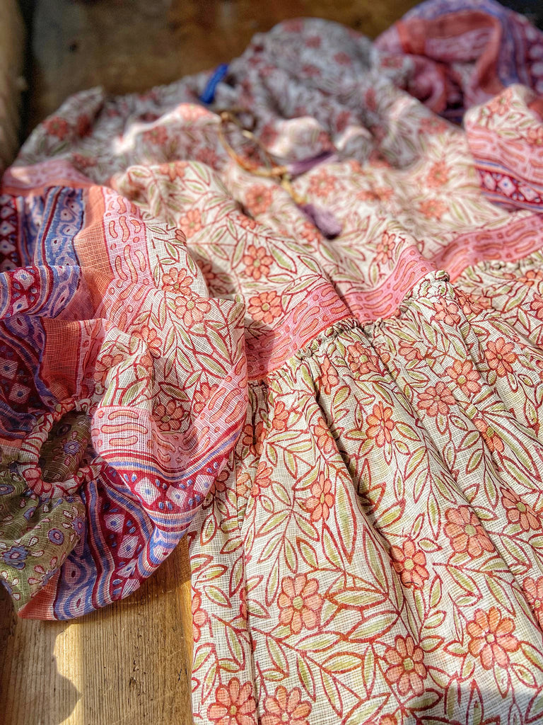 Summer floral apricot and lavender fine handwoven cotton block printed dress with long full sleeves and adjustable drawstring neckline. Bohemian styles sustainably created from antique and vintage textiles by the Pavilion Parade studio. 