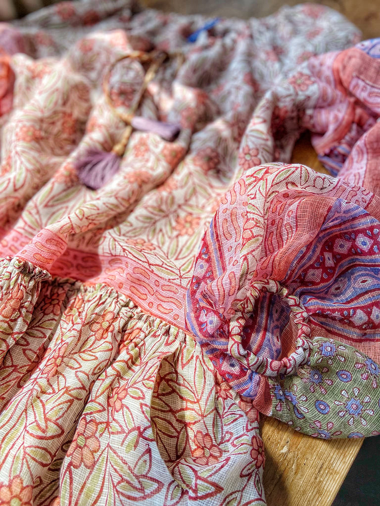 Summer floral apricot and lavender fine handwoven cotton block printed dress with long full sleeves and adjustable drawstring neckline. Bohemian styles sustainably created from antique and vintage textiles by the Pavilion Parade studio. 