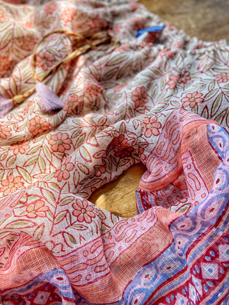 Summer floral apricot and lavender fine handwoven cotton block printed dress with long full sleeves and adjustable drawstring neckline. Bohemian styles sustainably created from antique and vintage textiles by the Pavilion Parade studio. 