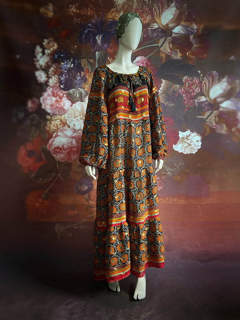 Black, burnt orange, and chilli red silk georgette maxi dress with tassel drawstring neckline, long full sleeves and side pockets. Bohemian style sustainably created from vintage and antique textiles by the Pavilion Parade studio.