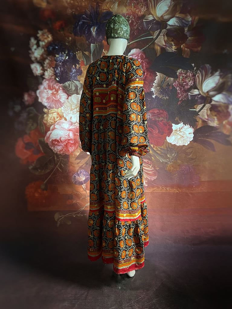 Black, burnt orange, and chilli red silk georgette maxi dress with tassel drawstring neckline, long full sleeves and side pockets. Bohemian style sustainably created from vintage and antique textiles by the Pavilion Parade studio.