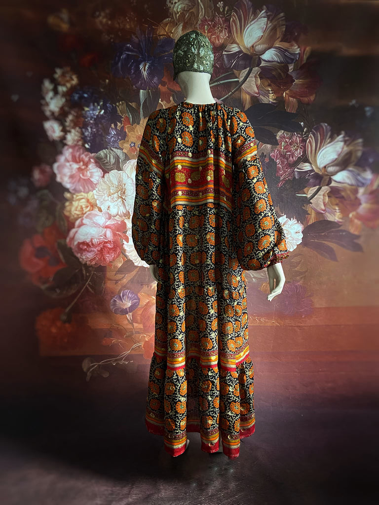 Black, burnt orange, and chilli red silk georgette maxi dress with tassel drawstring neckline, long full sleeves and side pockets. Bohemian style sustainably created from vintage and antique textiles by the Pavilion Parade studio.