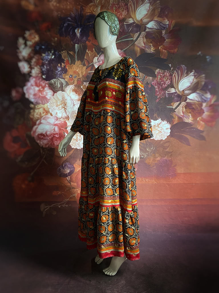 Black, burnt orange, and chilli red silk georgette maxi dress with tassel drawstring neckline, long full sleeves and side pockets. Bohemian style sustainably created from vintage and antique textiles by the Pavilion Parade studio.