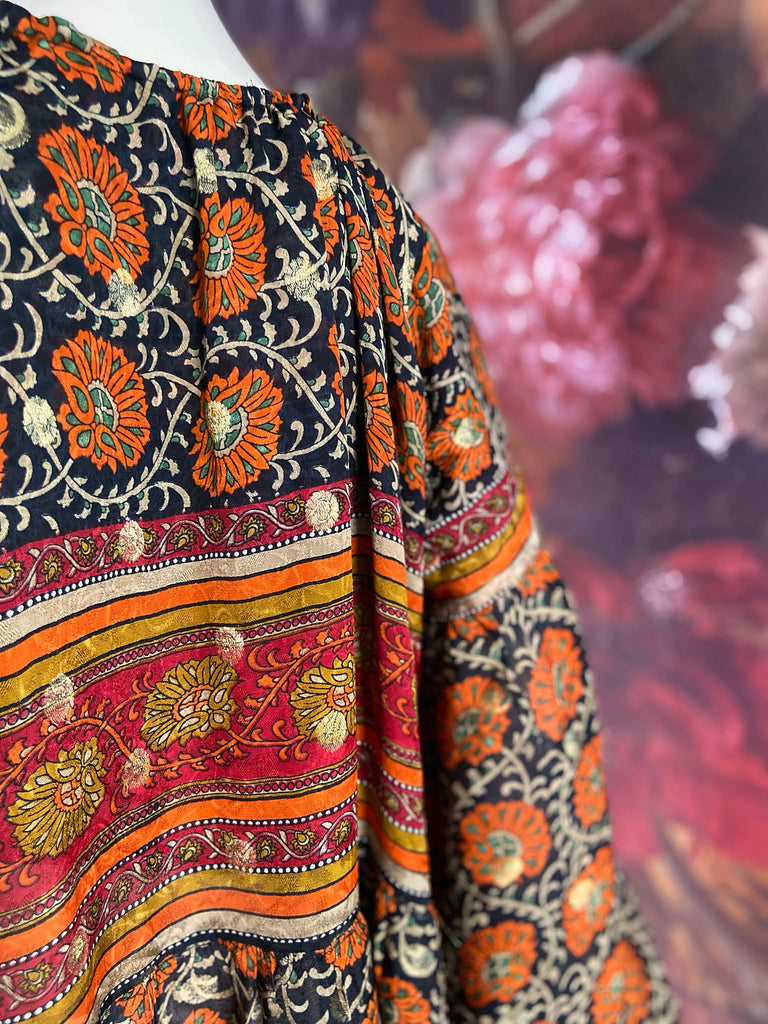 Black, burnt orange, and chilli red silk georgette maxi dress with tassel drawstring neckline, long full sleeves and side pockets. Bohemian style sustainably created from vintage and antique textiles by the Pavilion Parade studio.