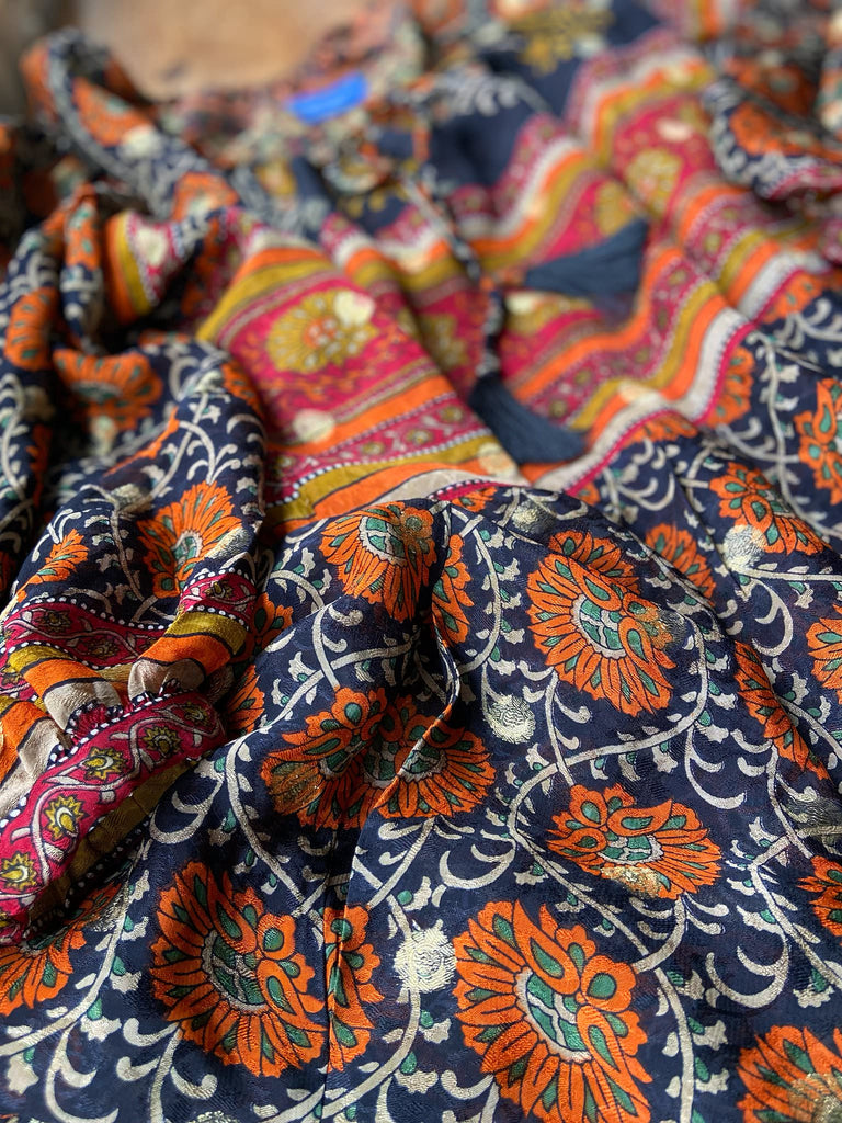 Black, burnt orange, and chilli red silk georgette maxi dress with tassel drawstring neckline, long full sleeves and side pockets. Bohemian style sustainably created from vintage and antique textiles by the Pavilion Parade studio.