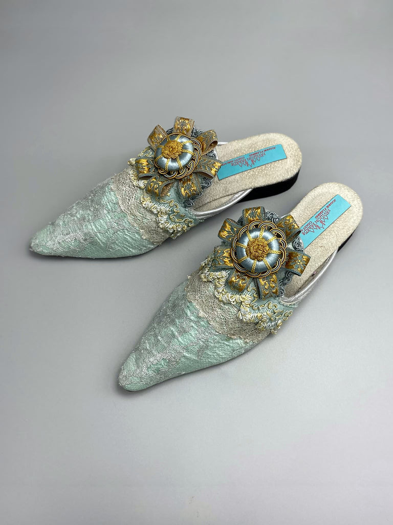 Silver lace and pale blue silk Georgian inspired mules with ribbon rosettes. Bohemian styles sustainably created from antique textiles by the Pavilion Parade studio.