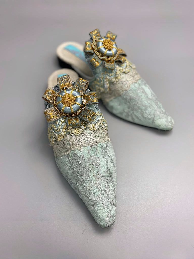 Silver lace and pale blue silk Georgian inspired mules with ribbon rosettes. Bohemian styles sustainably created from antique textiles by the Pavilion Parade studio.