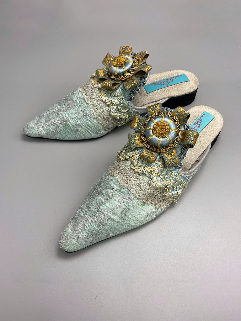 Silver lace and pale blue silk Georgian inspired mules with ribbon rosettes. Bohemian styles sustainably created from antique textiles by the Pavilion Parade studio.