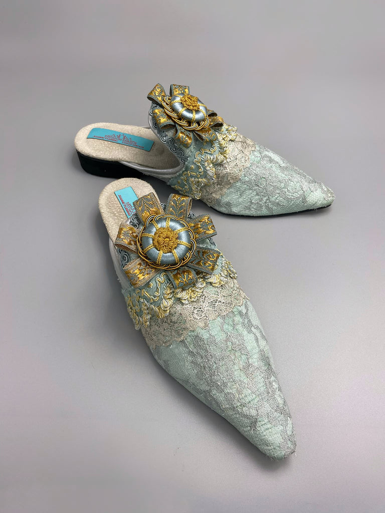 Silver lace and pale blue silk Georgian inspired mules with ribbon rosettes. Bohemian styles sustainably created from antique textiles by the Pavilion Parade studio.