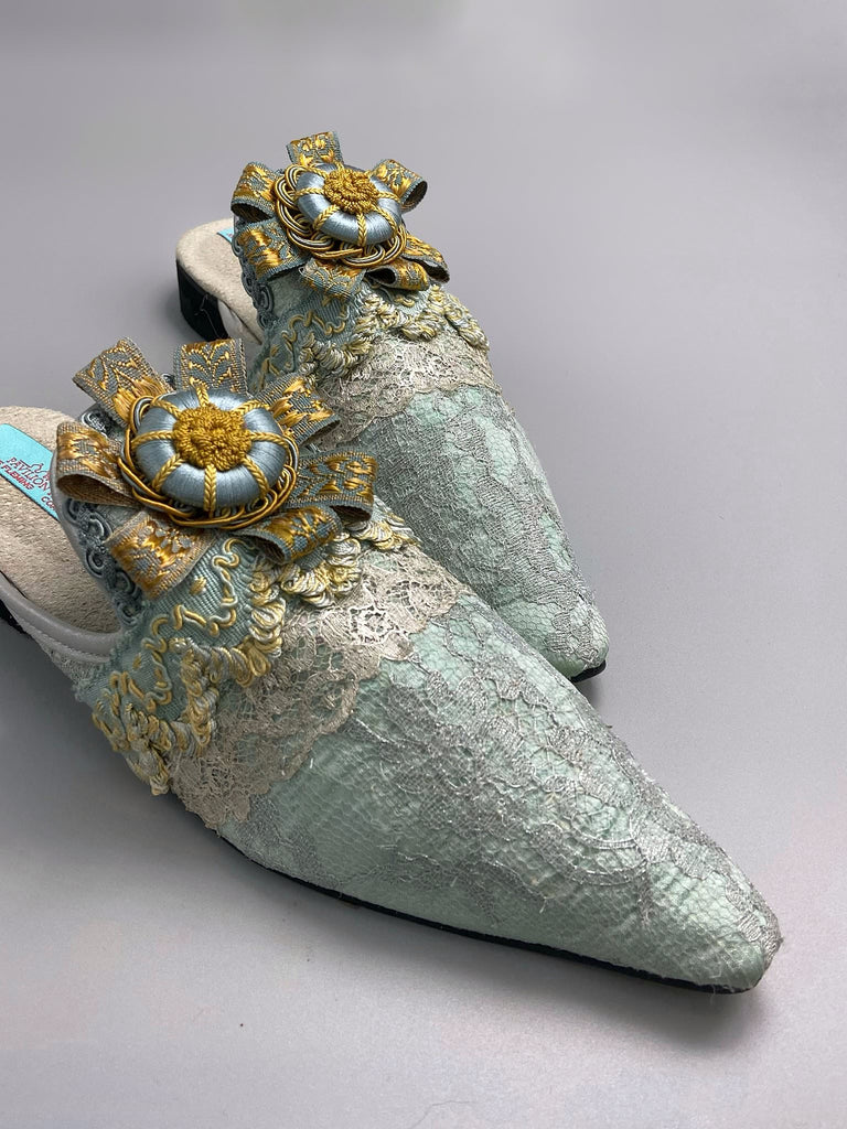Silver lace and pale blue silk Georgian inspired mules with ribbon rosettes. Bohemian styles sustainably created from antique textiles by the Pavilion Parade studio.