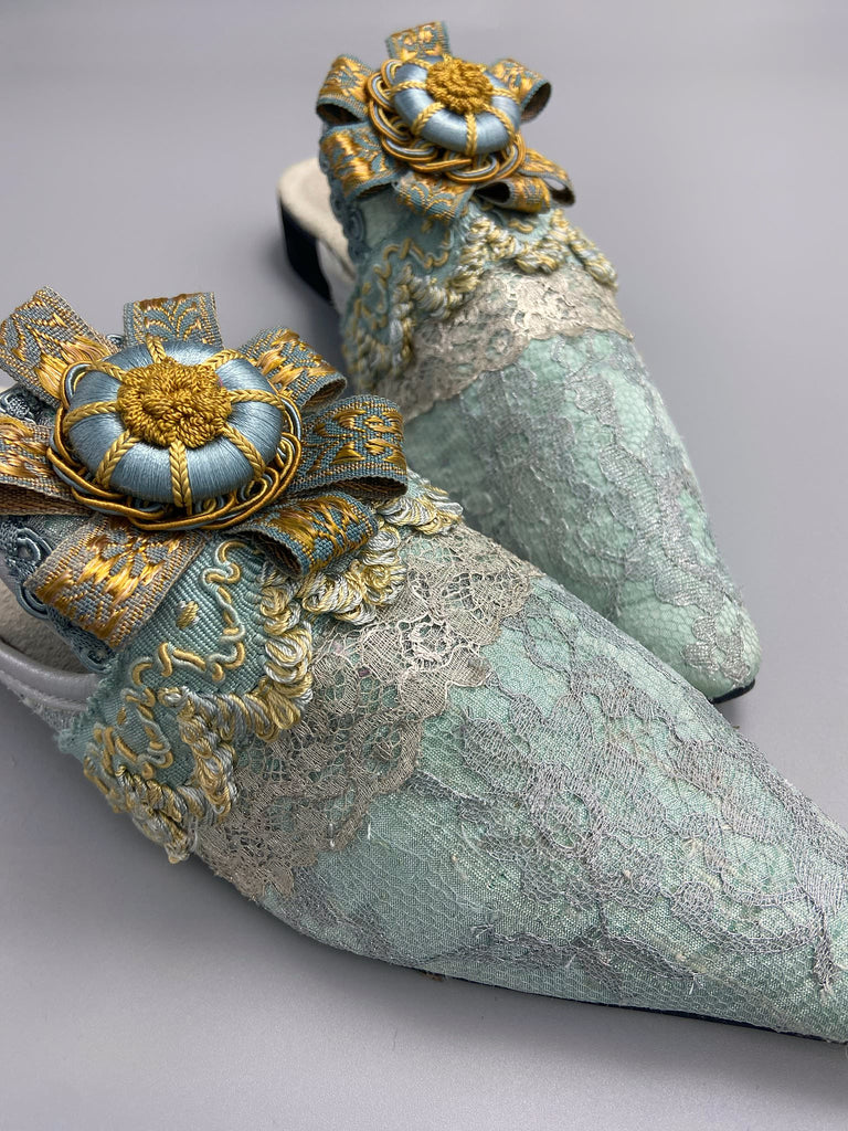 Silver lace and pale blue silk Georgian inspired mules with ribbon rosettes. Bohemian styles sustainably created from antique textiles by the Pavilion Parade studio.