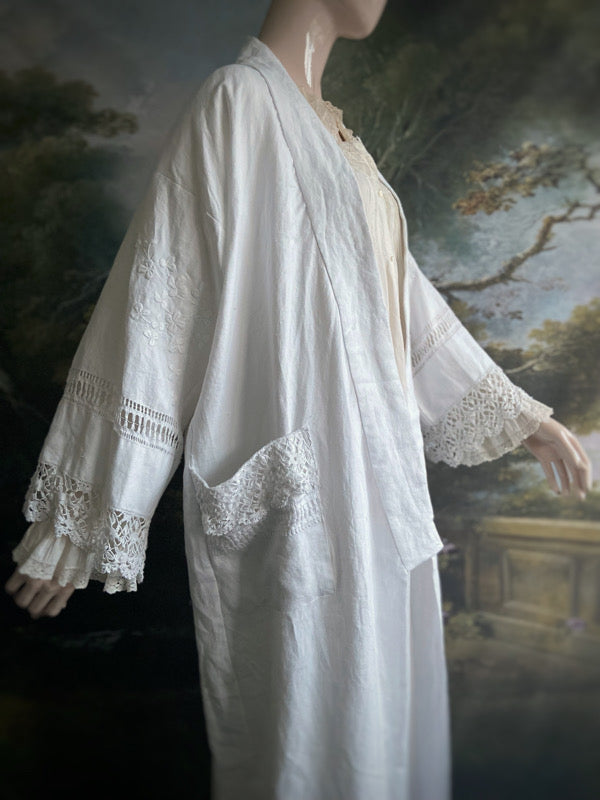 Full length kimono inspired robe with large patch pockets and wide sleeves. Created from an antique Irish linen monogrammed sheet with hand embroidered clover leaves, lace and drawn thread work. All French seamed with hand finished hems and collar. Bohemian styles sustainably created from antique and vintage textiles by the Pavilion Parade studio.
