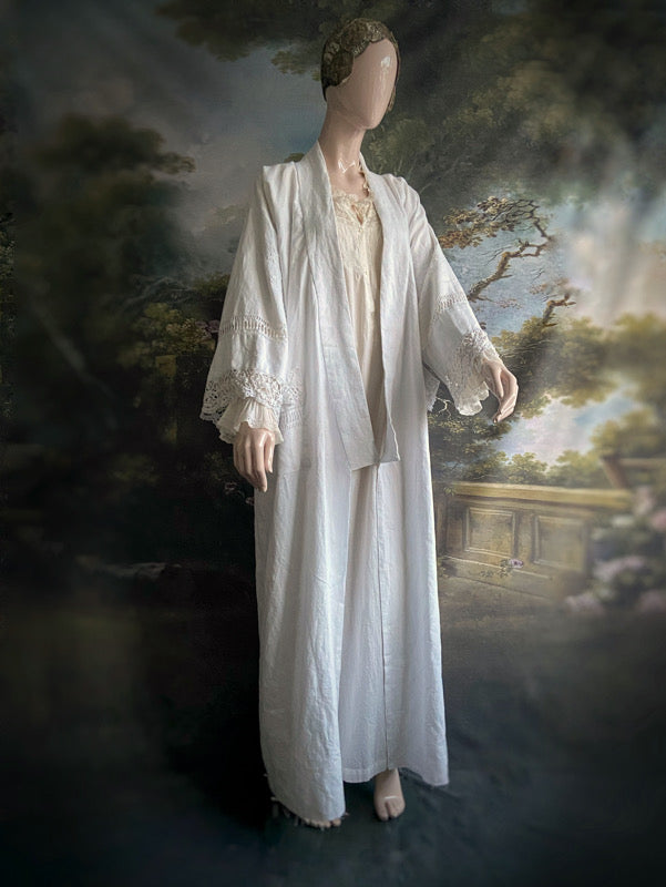 Full length kimono inspired robe with large patch pockets and wide sleeves. Created from an antique Irish linen monogrammed sheet with hand embroidered clover leaves, lace and drawn thread work. All French seamed with hand finished hems and collar. Bohemian styles sustainably created from antique and vintage textiles by the Pavilion Parade studio.