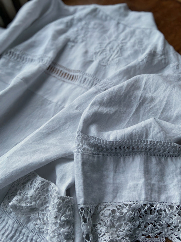 Full length kimono inspired robe with large patch pockets and wide sleeves. Created from an antique Irish linen monogrammed sheet with hand embroidered clover leaves, lace and drawn thread work. All French seamed with hand finished hems and collar. Bohemian styles sustainably created from antique and vintage textiles by the Pavilion Parade studio.