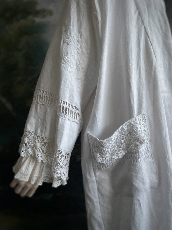 Full length kimono inspired robe with large patch pockets and wide sleeves. Created from an antique Irish linen monogrammed sheet with hand embroidered clover leaves, lace and drawn thread work. All French seamed with hand finished hems and collar. Bohemian styles sustainably created from antique and vintage textiles by the Pavilion Parade studio.