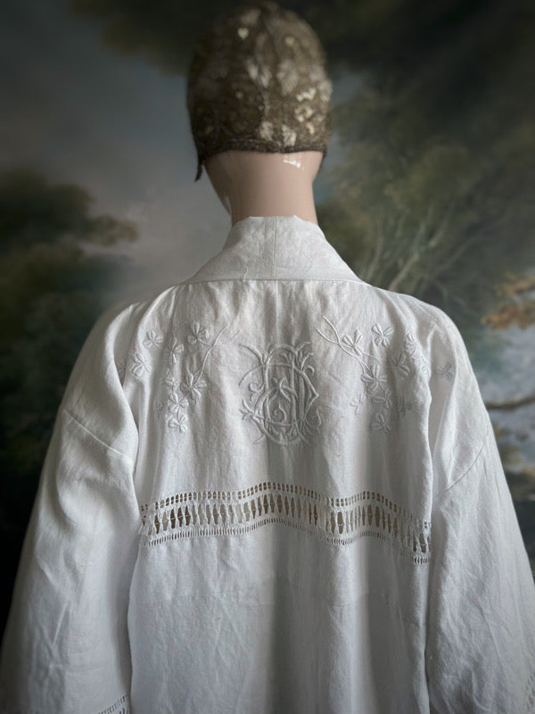 Full length kimono inspired robe with large patch pockets and wide sleeves. Created from an antique Irish linen monogrammed sheet with hand embroidered clover leaves, lace and drawn thread work. All French seamed with hand finished hems and collar. Bohemian styles sustainably created from antique and vintage textiles by the Pavilion Parade studio.
