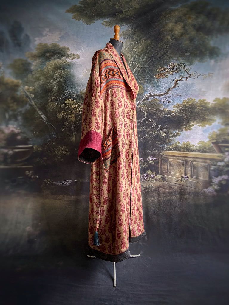 Burgundy red, sand and pumpkin orange fine wool robe with peacock motif silk lining. Wide sleeves, deep pockets and tassel sash. Unique bohemian style created from vintage and antique textiles by the Pavilion Parade studio.