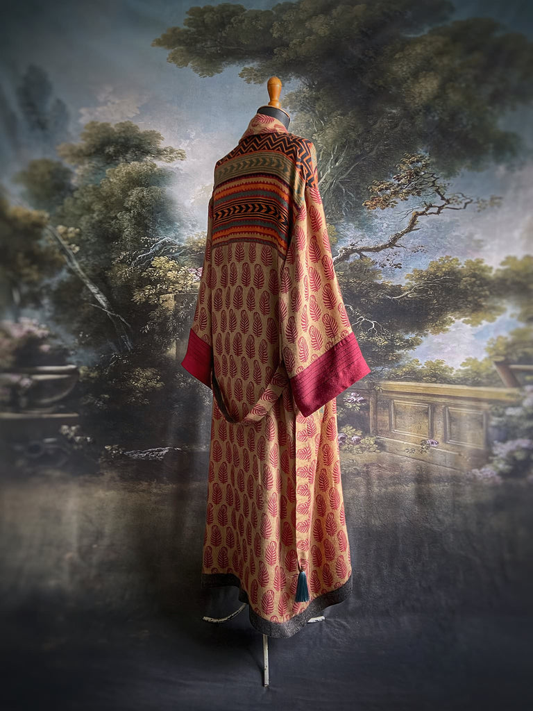 Burgundy red, sand and pumpkin orange fine wool robe with peacock motif silk lining. Wide sleeves, deep pockets and tassel sash. Unique bohemian style created from vintage and antique textiles by the Pavilion Parade studio.