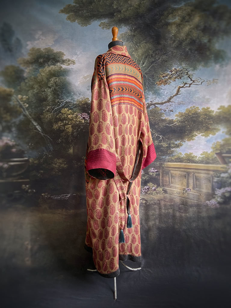 Burgundy red, sand and pumpkin orange fine wool robe with peacock motif silk lining. Wide sleeves, deep pockets and tassel sash. Unique bohemian style created from vintage and antique textiles by the Pavilion Parade studio.