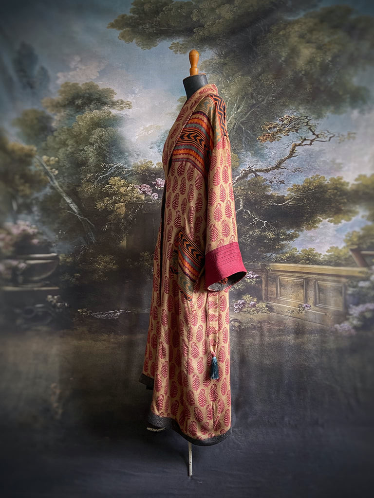 Burgundy red, sand and pumpkin orange fine wool robe with peacock motif silk lining. Wide sleeves, deep pockets and tassel sash. Unique bohemian style created from vintage and antique textiles by the Pavilion Parade studio.