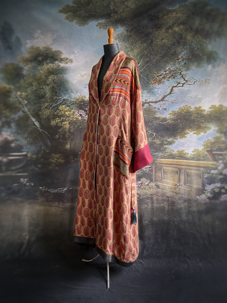 Burgundy red, sand and pumpkin orange fine wool robe with peacock motif silk lining. Wide sleeves, deep pockets and tassel sash. Unique bohemian style created from vintage and antique textiles by the Pavilion Parade studio.